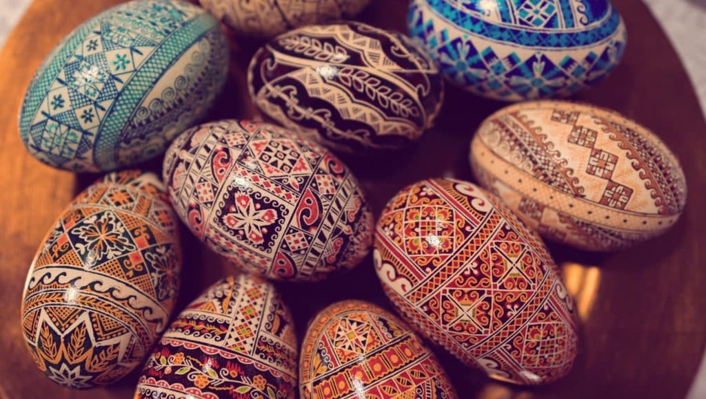 A bunch of brightly decorated eggs with patters, flowers, and vibrant colors