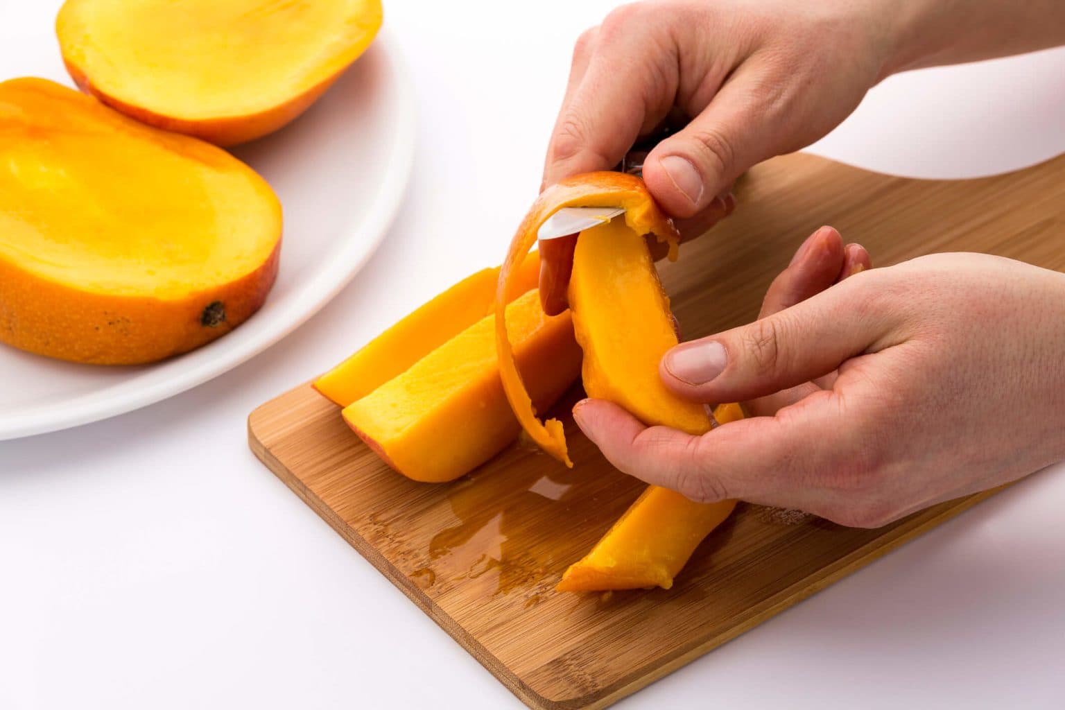 A person slicing mangos