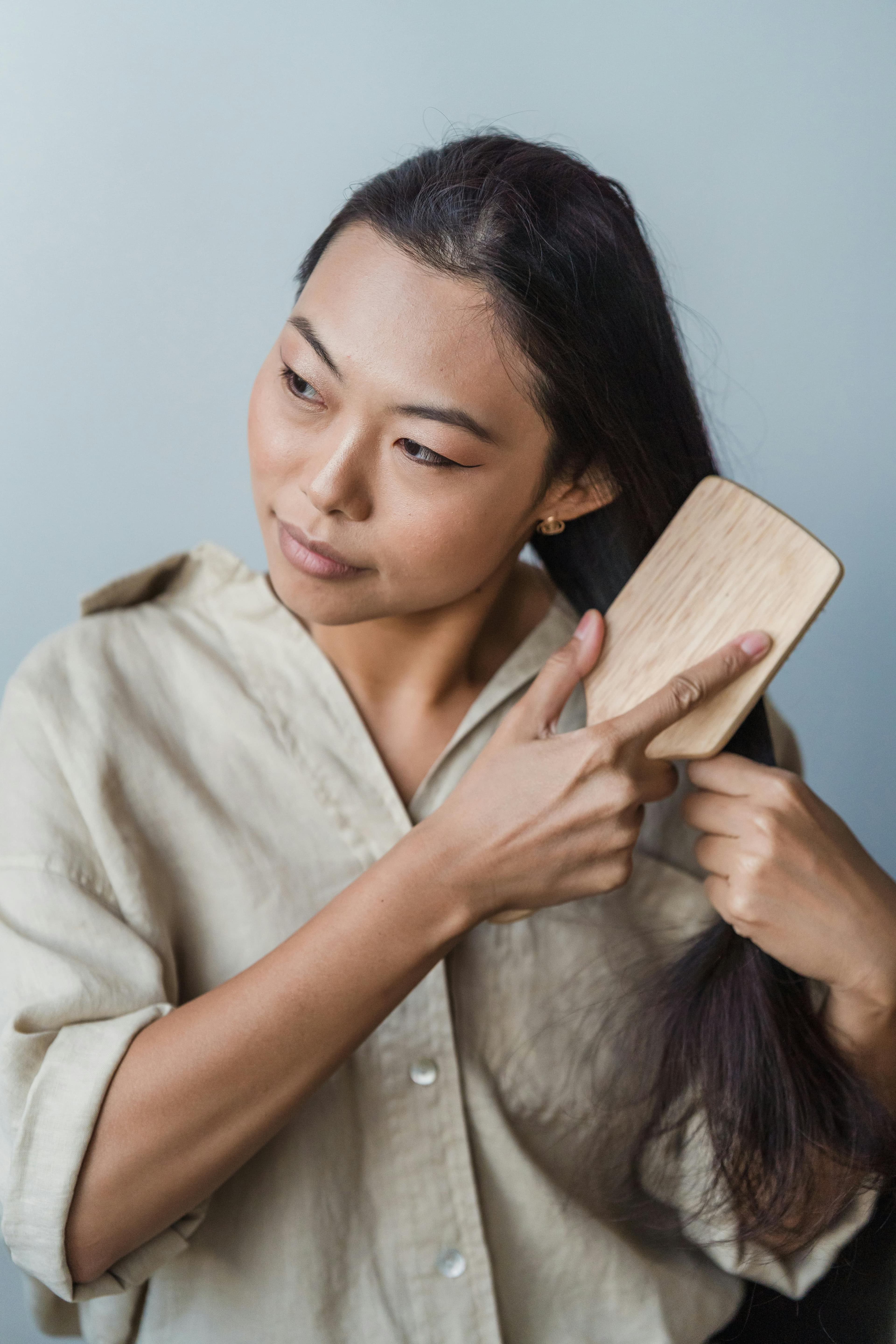 A photo of a woman brushing her hair.