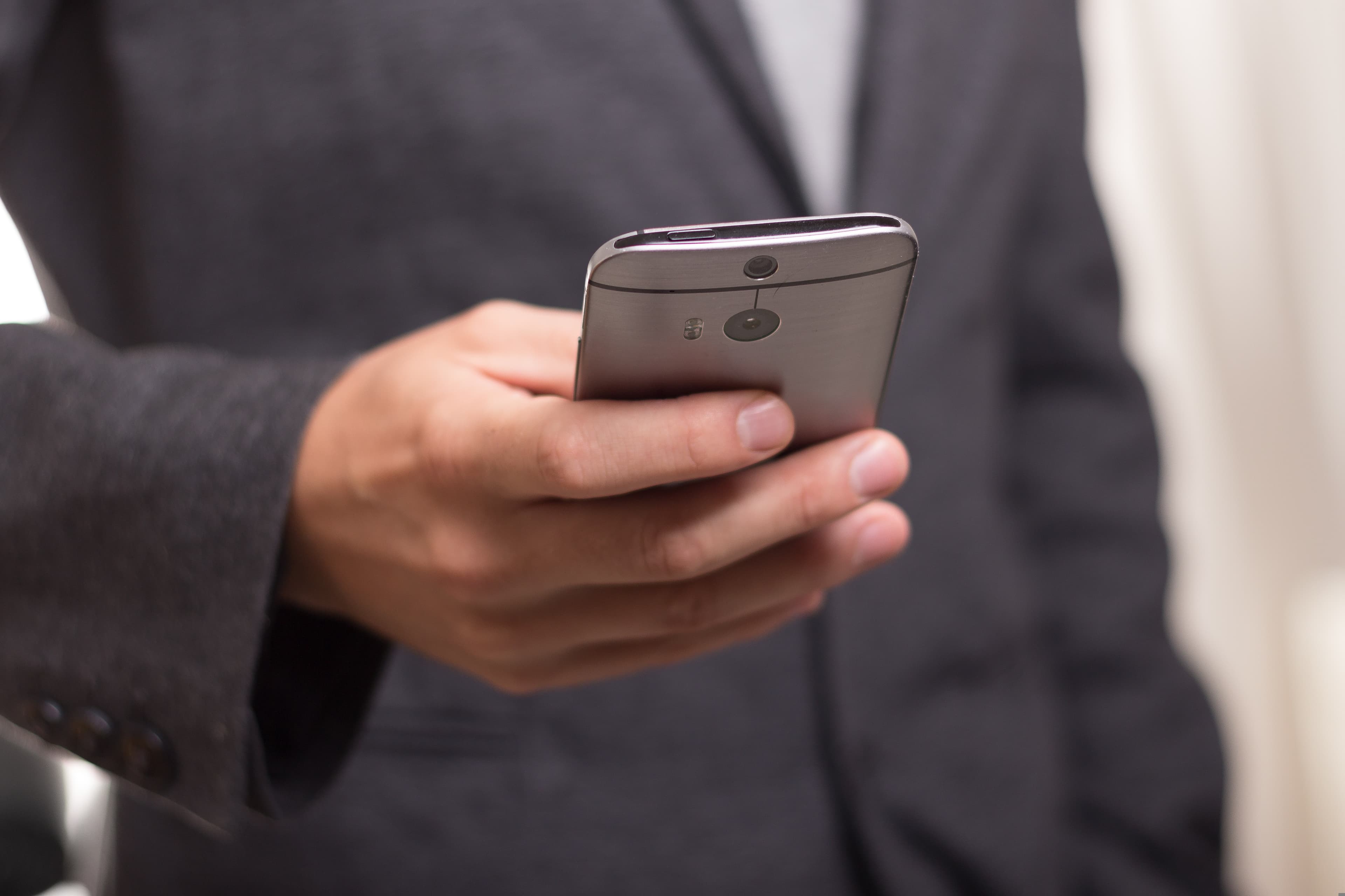 A cell phone. We can tell it is being held by a man in a suit.