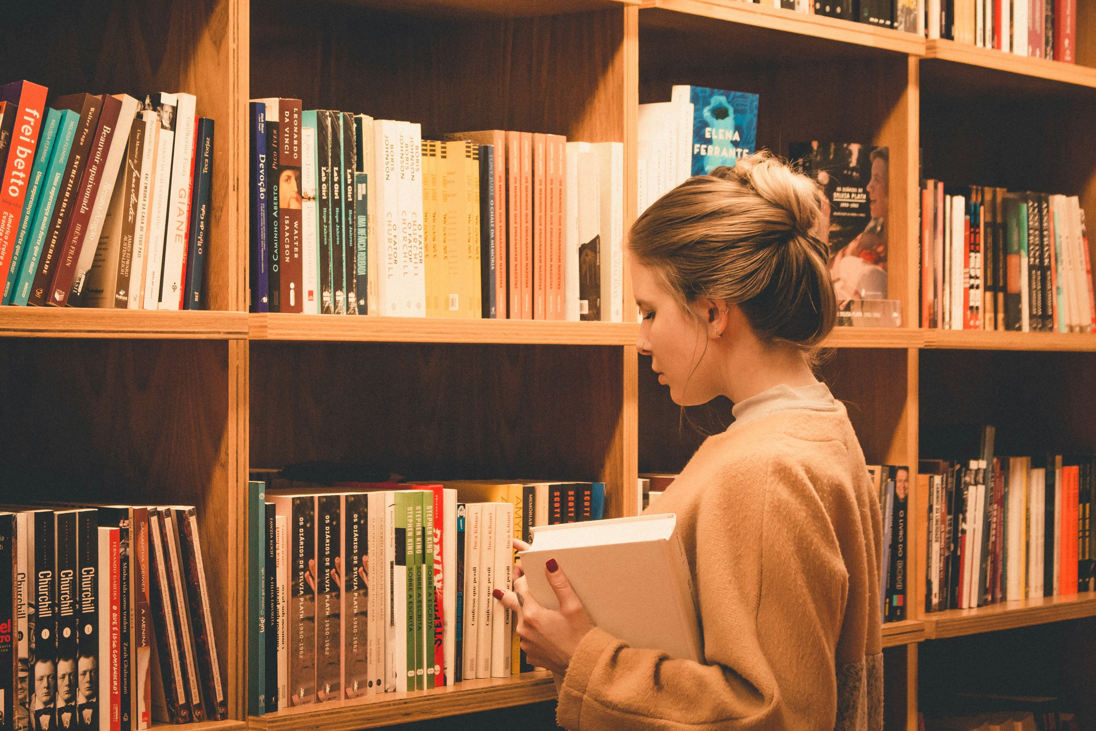 A woman picking out books at the library.