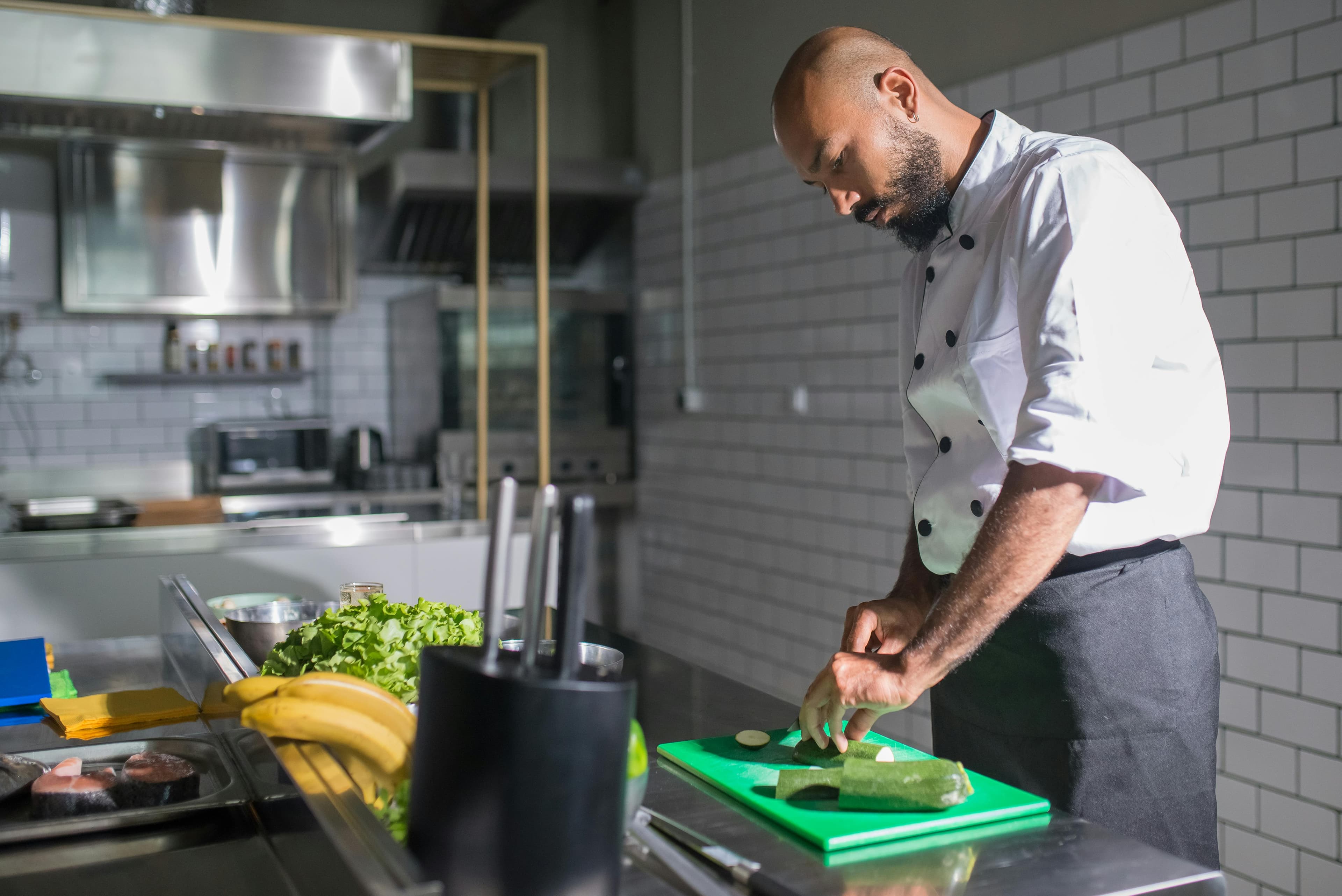 A chef cuts zucchini.
