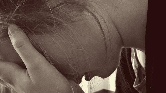 Woman holding her face between her hands