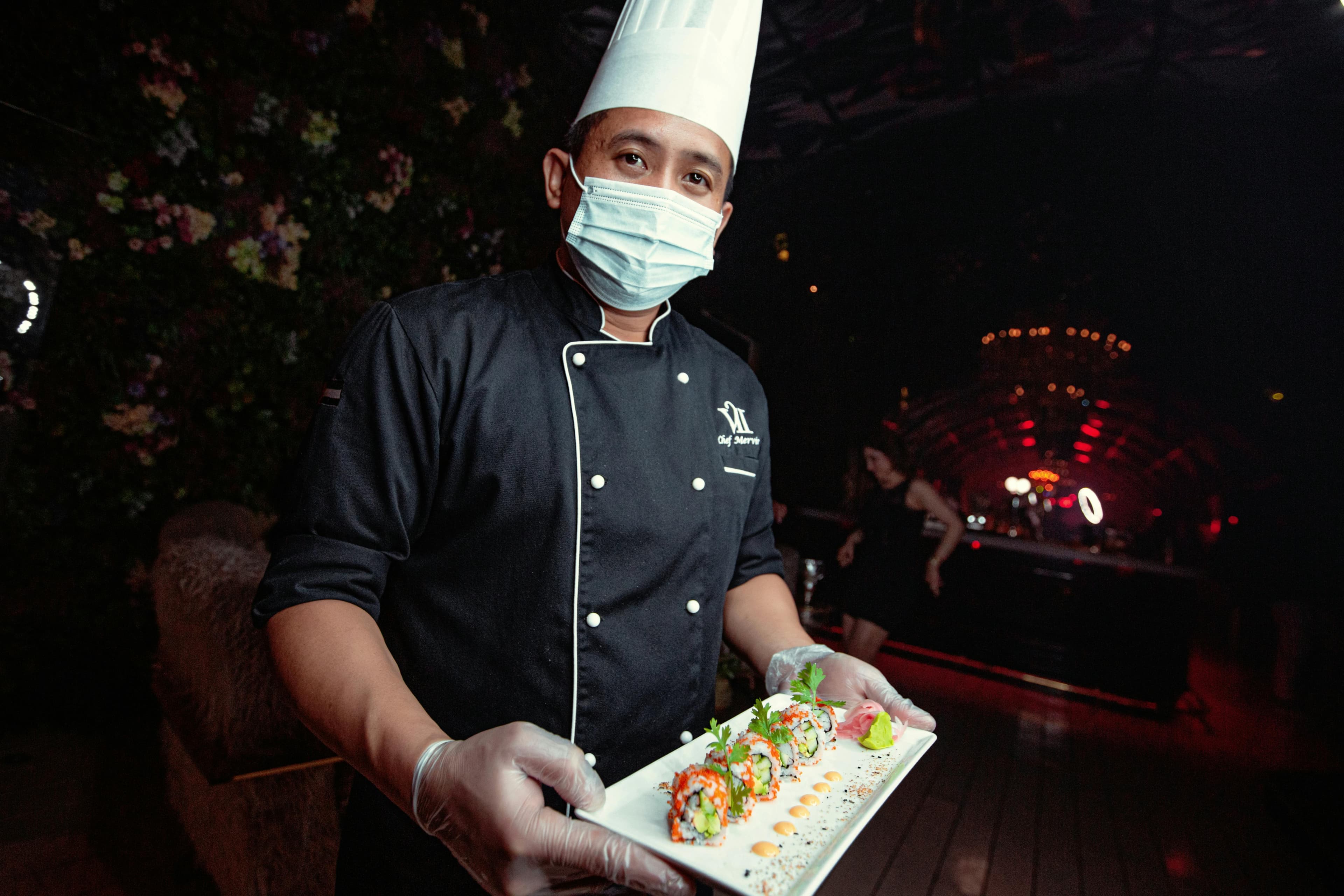 A chef shows off a plate of sushi.