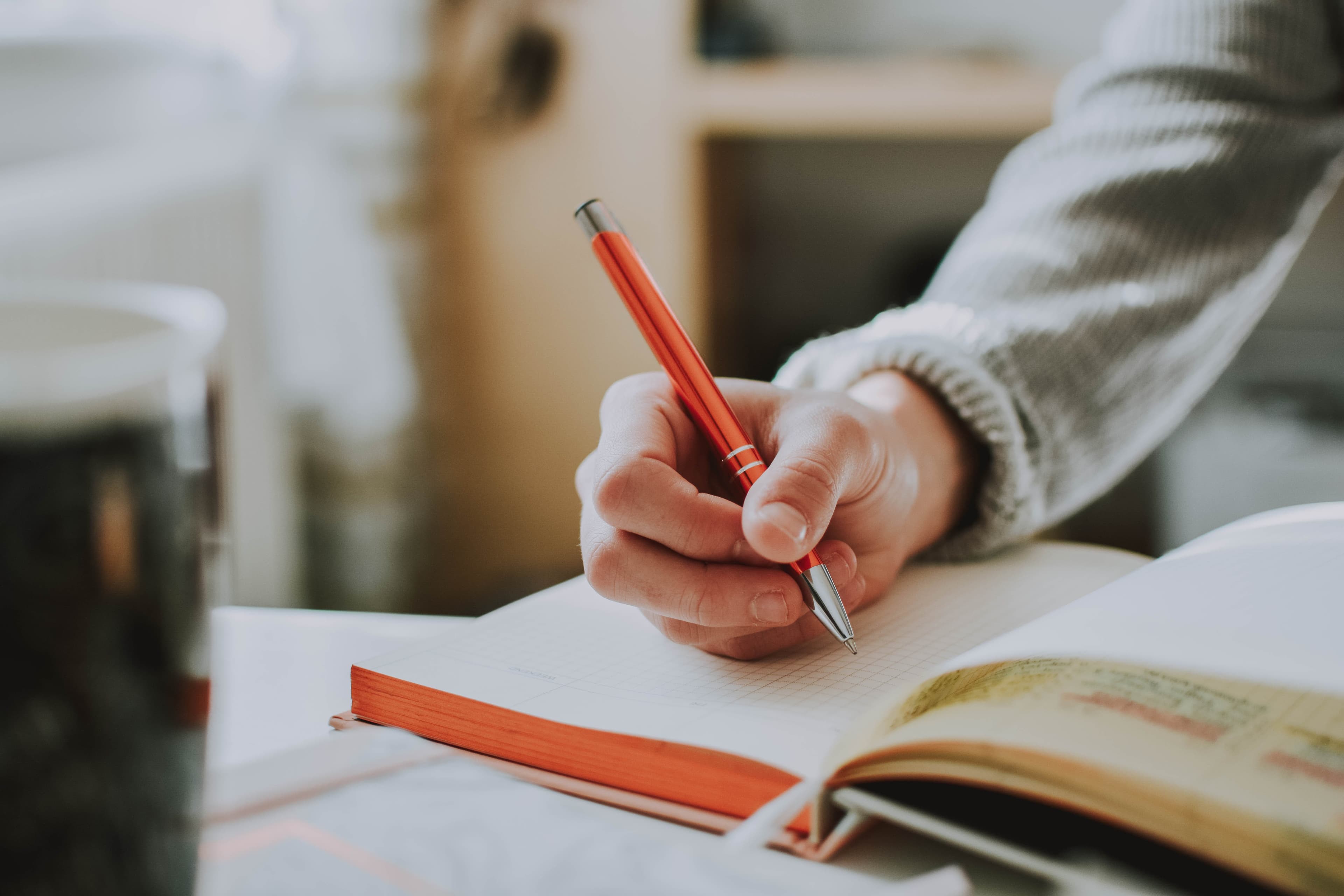 A hand writing in a notebook