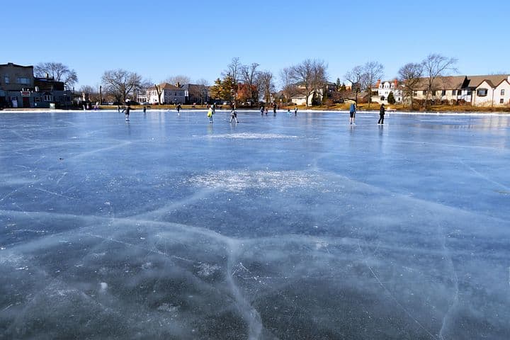 ice skaters on a lake in a small town