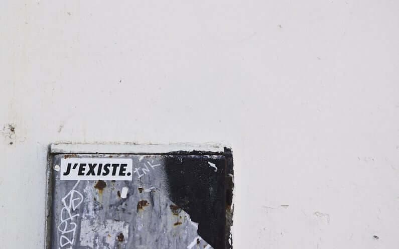 A mural that says: "J'existe", which means "I exist"