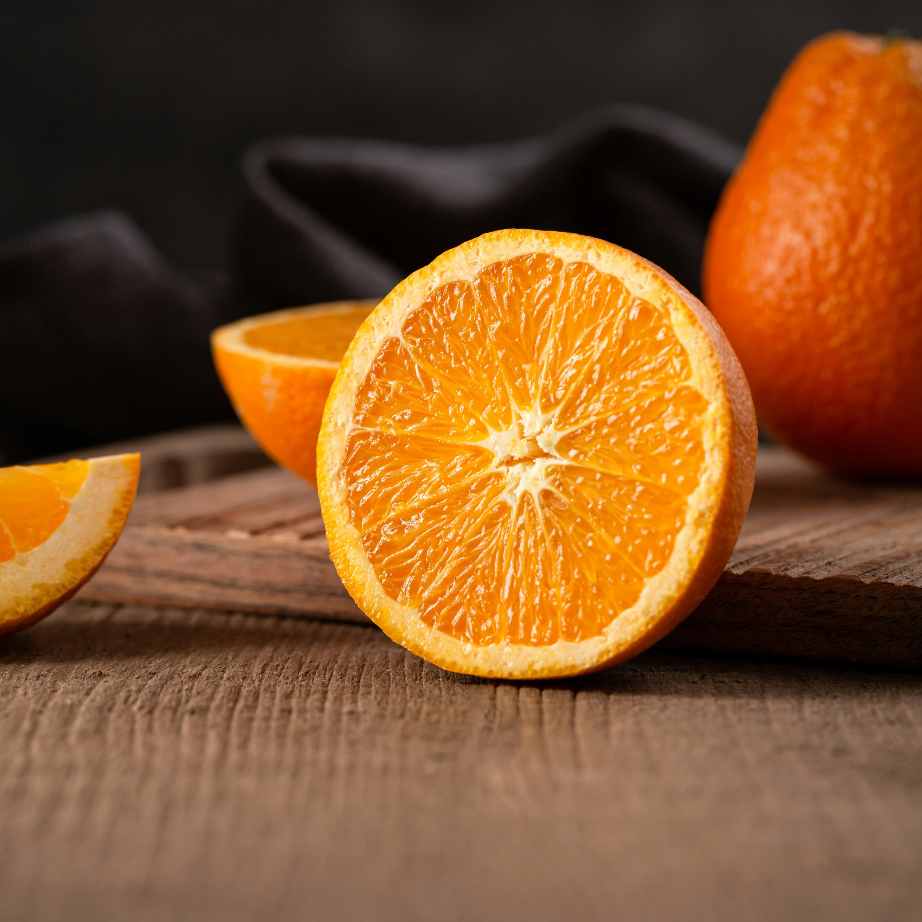 An orange that is sliced in half sitting on a table.