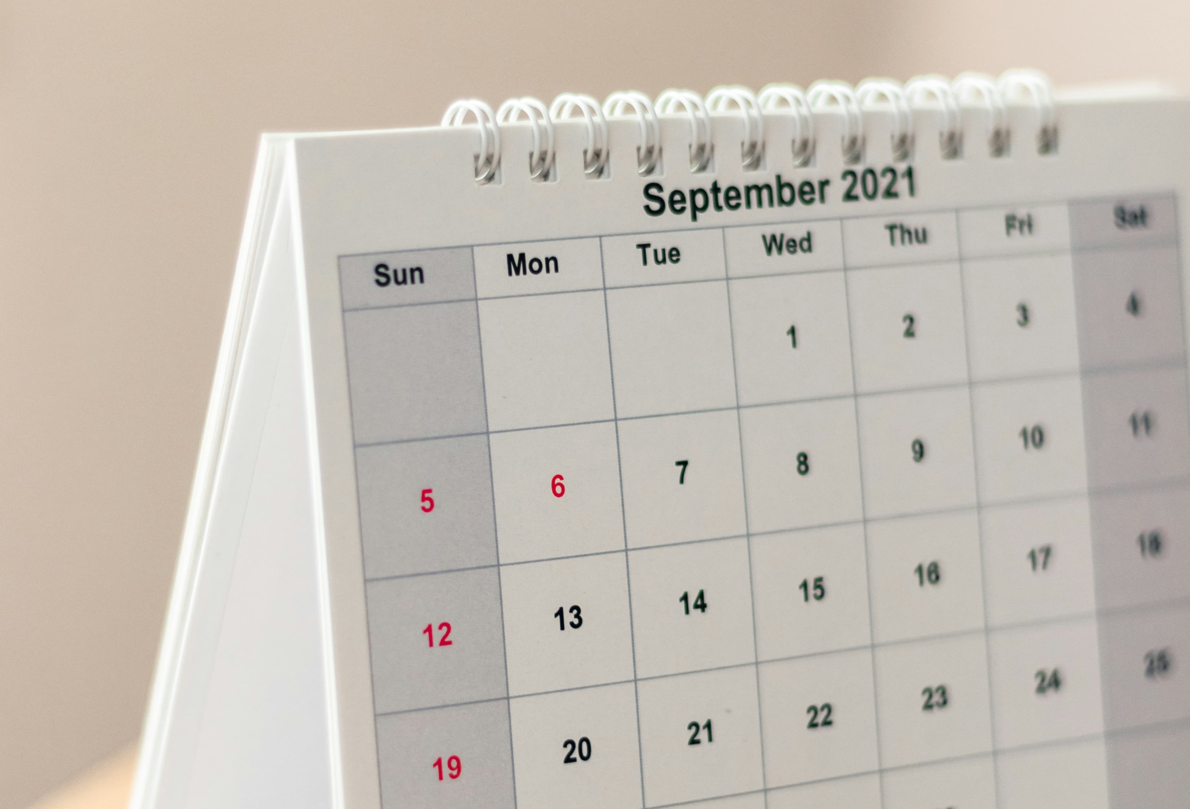 A photo of a desk calendar resting on a table. It reads "September 2021."
