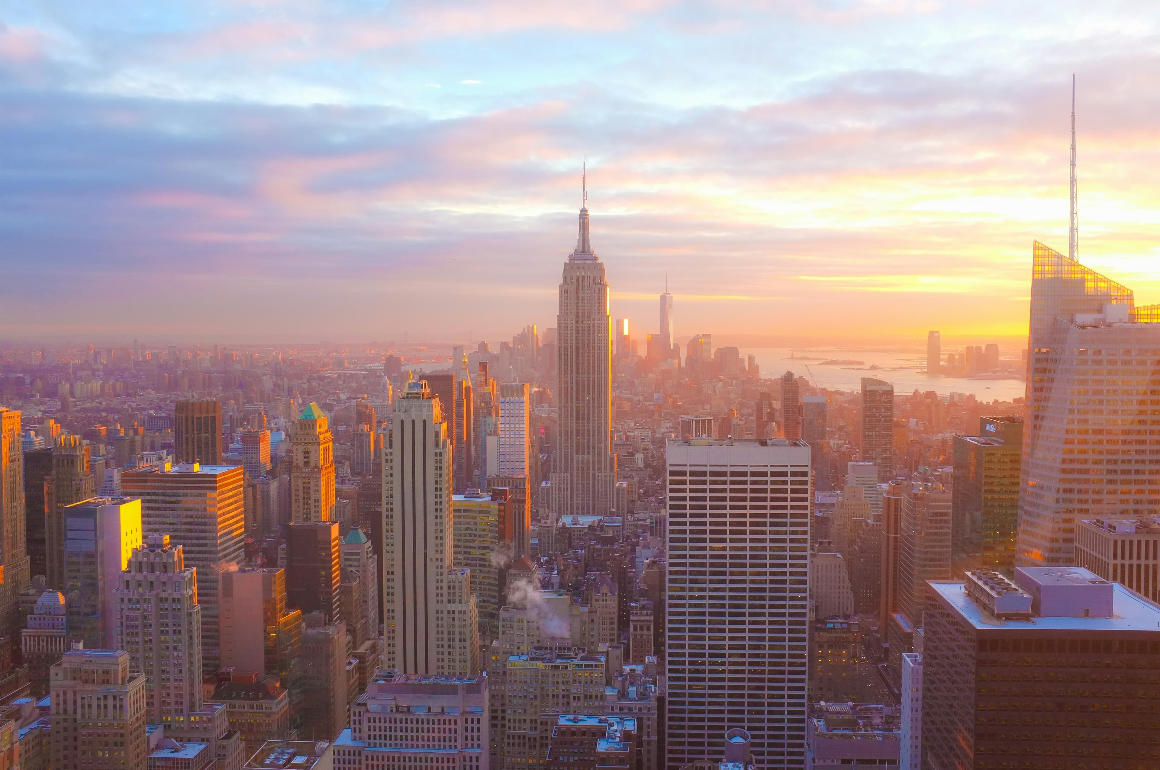 A photo of the Empire State Building and the Manhattan skyline at sunset.