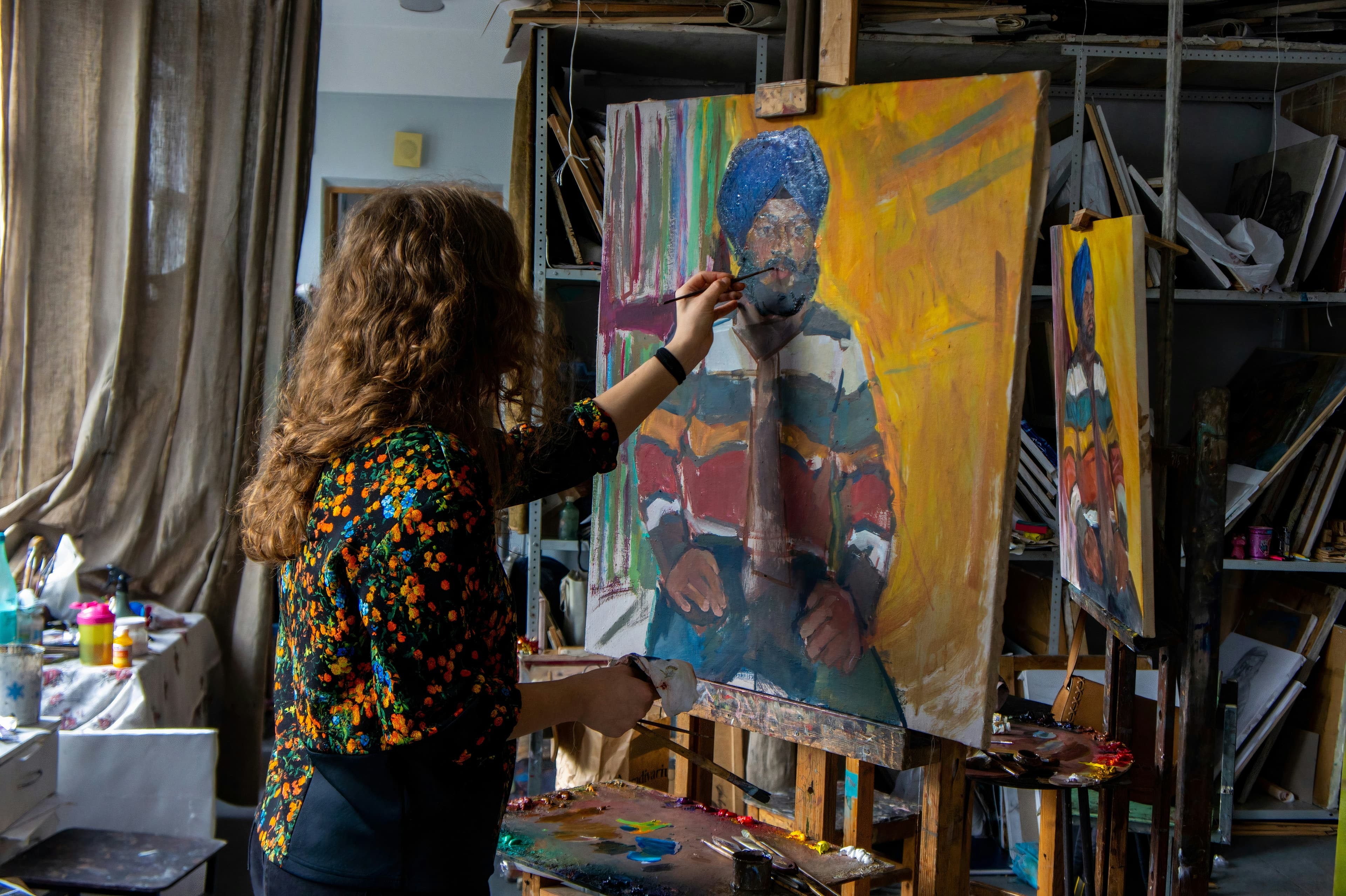 A photo of a woman painting a portrait.
