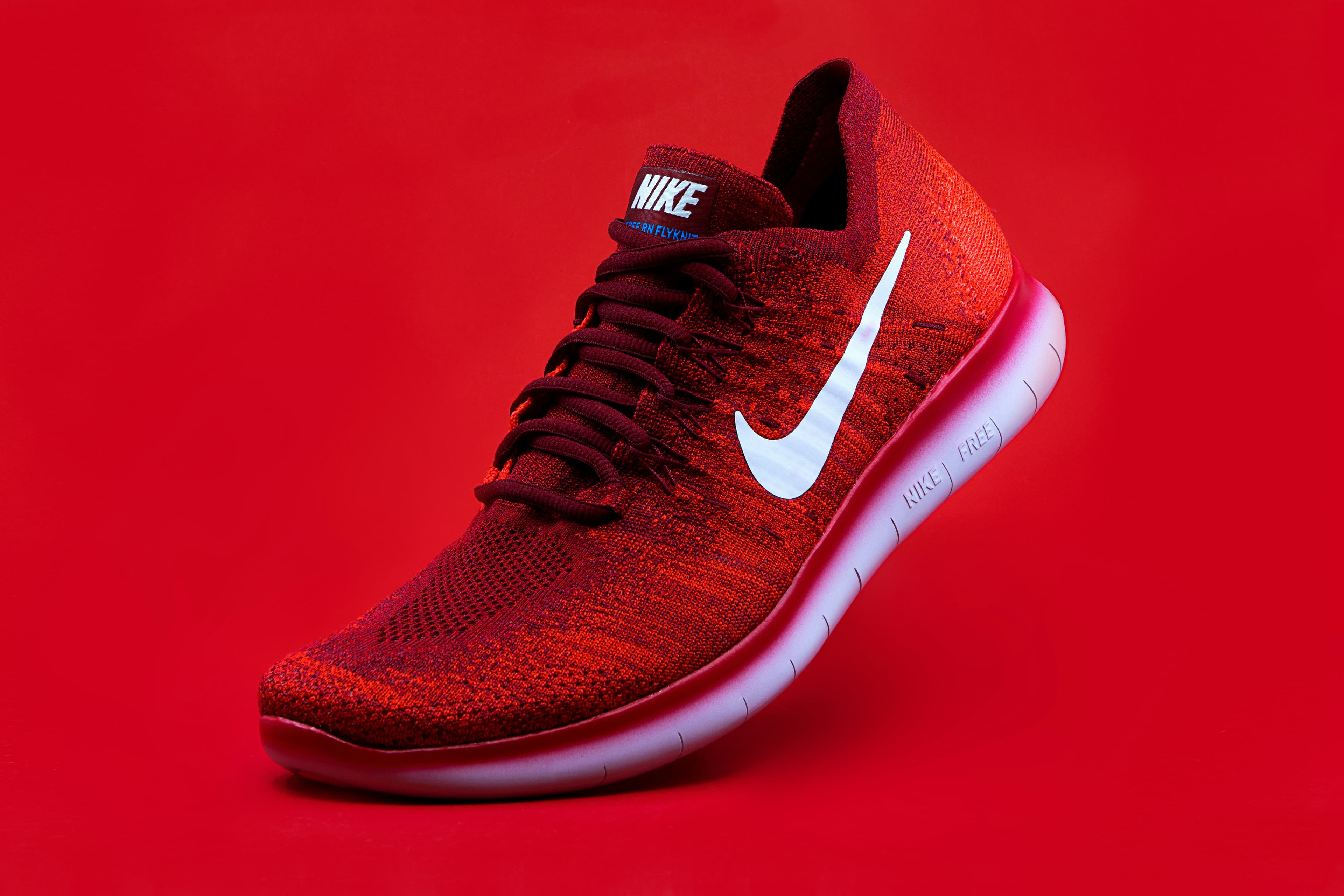 A red Nike brand shoe pictured against a red background.