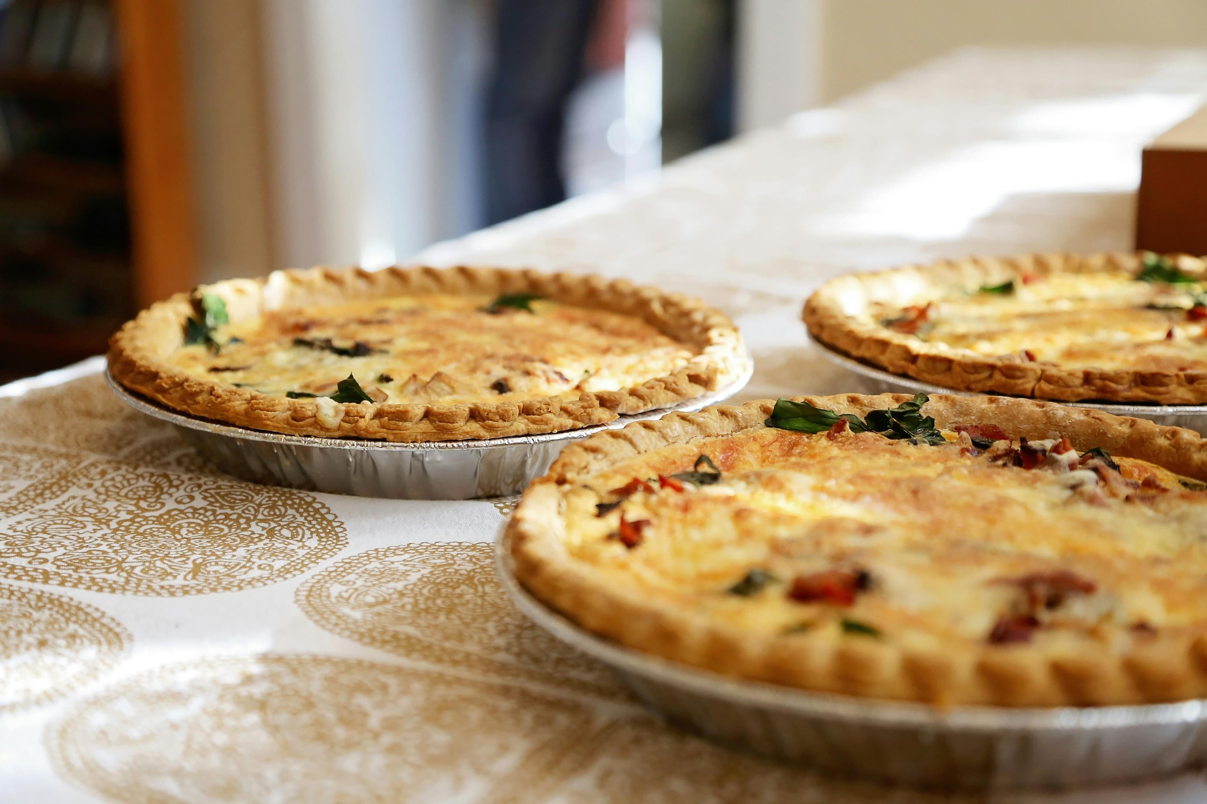Three pies sit on a tablecloth.
