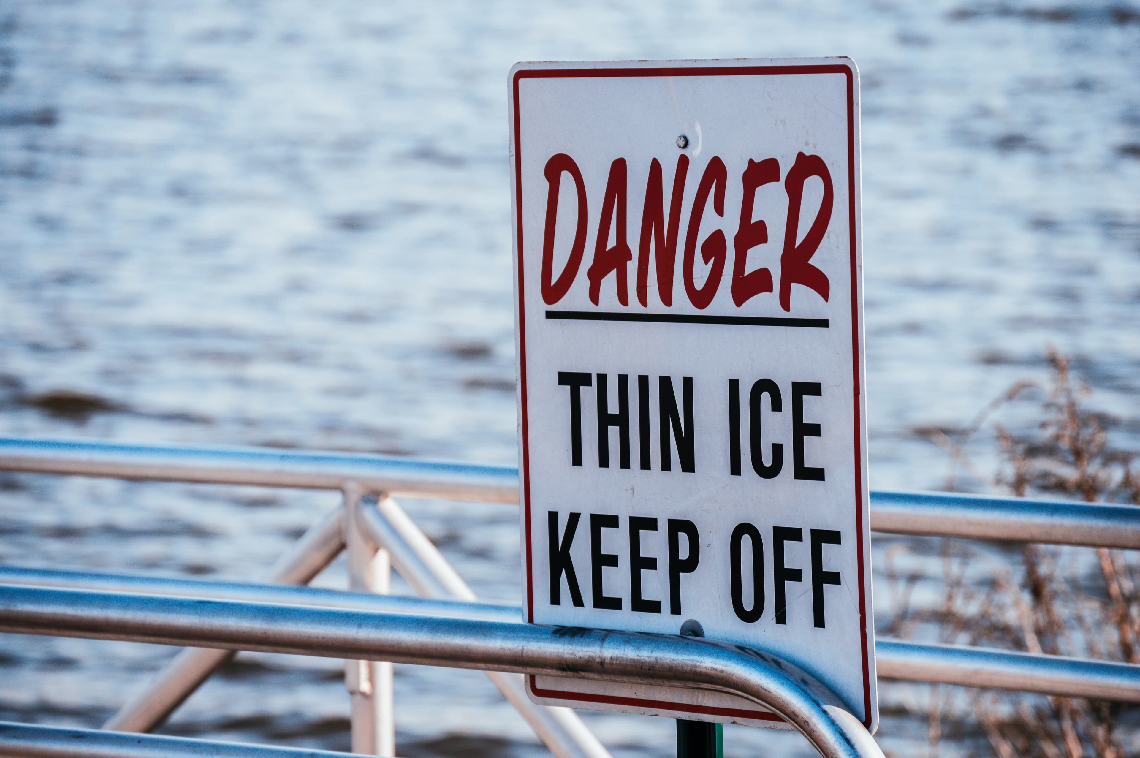 A rectangular sign reading "Danger," (in red) "thin ice, keep off" (in black)
