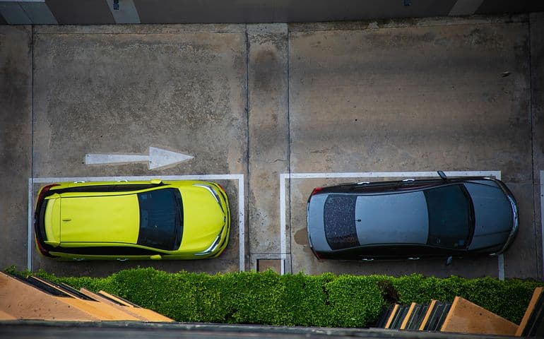 Two cars, parallel parked in a line.