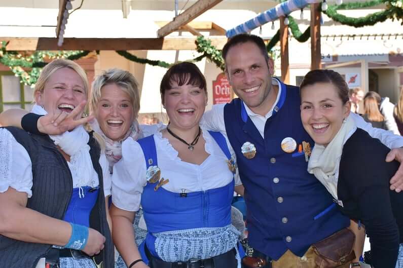 A group of people dressed in blue and white Oktoberfest outfits.